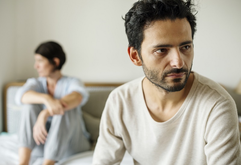 sociopath narcissistic - try betterhelp online therapy and counseling today with an experienced, licensed counselor available to chat via message, phone, or video - image description: woman on head of bed looking away and upset while man is sitting on the foot of the bed looking angry or annoyed.